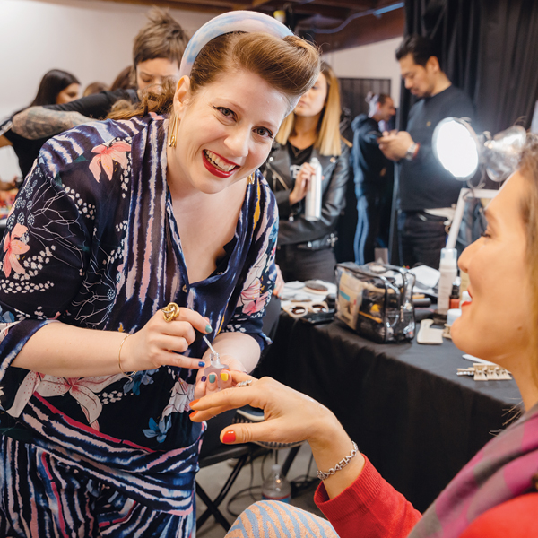 Lead nail tech Miss Pop polishing nails backstage.