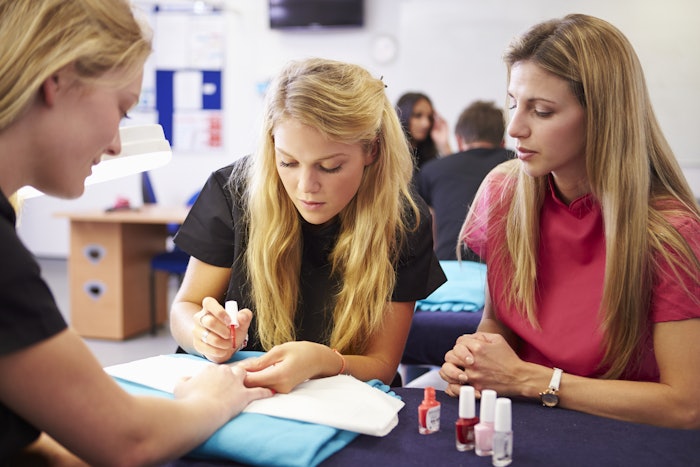 Nail educator helping students in training
