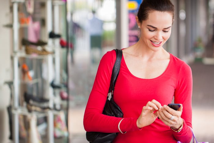 woman smiling down at her phone