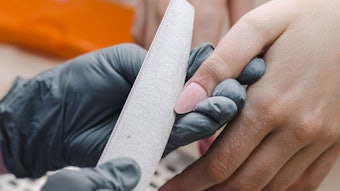 Manicurist shaping the nail
